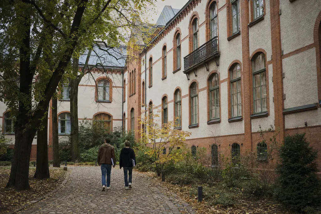 Clădire universitară neoclasică cu cupolă, văzută dintr-o piață pavată la amurg (imagine generată cu AI)